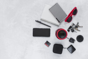 elevated-view-camera-lens-spiral-notebook-cellphone-personal-accessories-background
